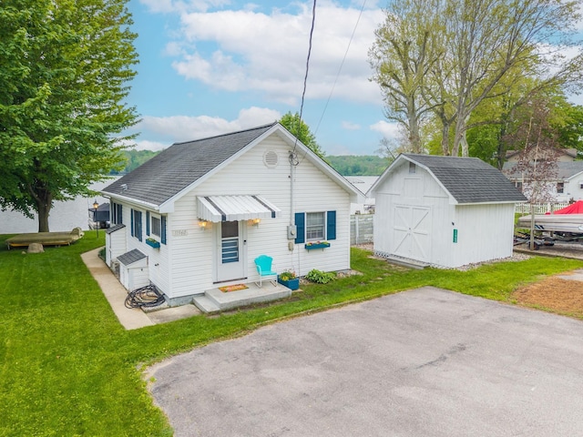 11960 E 660 Lake S, Lake, Hudson, IN 46747 - view of front of home featuring a storage shed, an outdoor structure, a front lawn, and roof with shingles