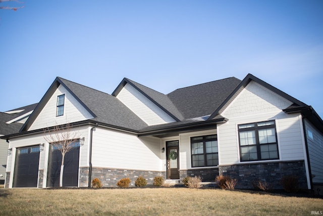 735 E Holland Dr, Bloomington, IN 47401 - view of front of house with a front yard, stone siding, a shingled roof, and a garage