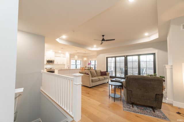 735 E Holland Dr, Bloomington, IN 47401 - living room featuring a tray ceiling, ceiling fan, light wood-style flooring, french doors, and recessed lighting