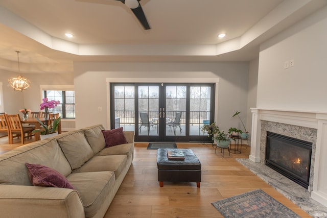 735 E Holland Dr, Bloomington, IN 47401 - living room with a tray ceiling, ceiling fan, a chandelier, a fireplace, and recessed lighting