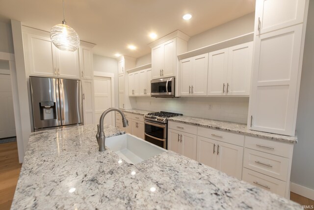 735 E Holland Dr, Bloomington, IN 47401 - kitchen with appliances with stainless steel finishes, a sink, backsplash, white cabinets, and recessed lighting