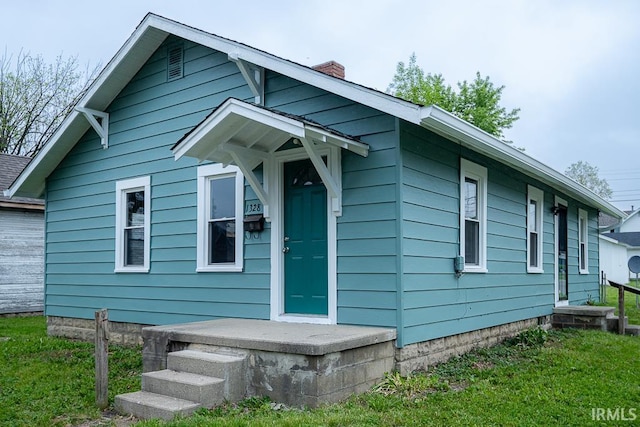 view of front of property with a chimney and a front yard
