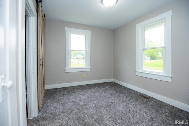 unfurnished bedroom with baseboards and dark colored carpet
