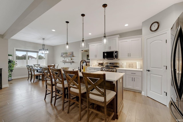 201 Thoroughbred Ln, Auburn, IN 46706 - kitchen with stainless steel appliances, light countertops, a breakfast bar area, a center island with sink, and recessed lighting