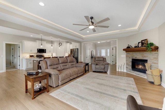 201 Thoroughbred Ln, Auburn, IN 46706 - living room with a raised ceiling, ceiling fan, a fireplace, light wood-style flooring, and recessed lighting