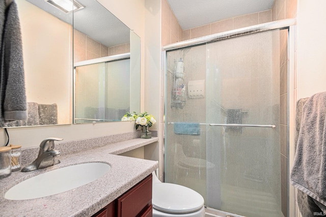 bathroom featuring a stall shower, vanity, and toilet