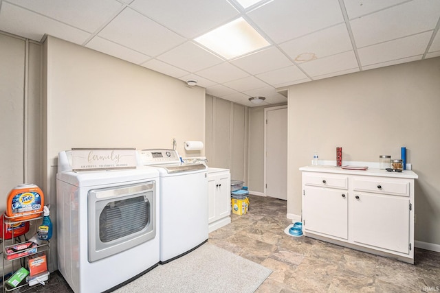 laundry room featuring washer and dryer, cabinet space, and baseboards