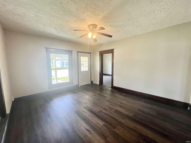 spare room with dark wood-style flooring, a textured ceiling, a ceiling fan, and baseboards