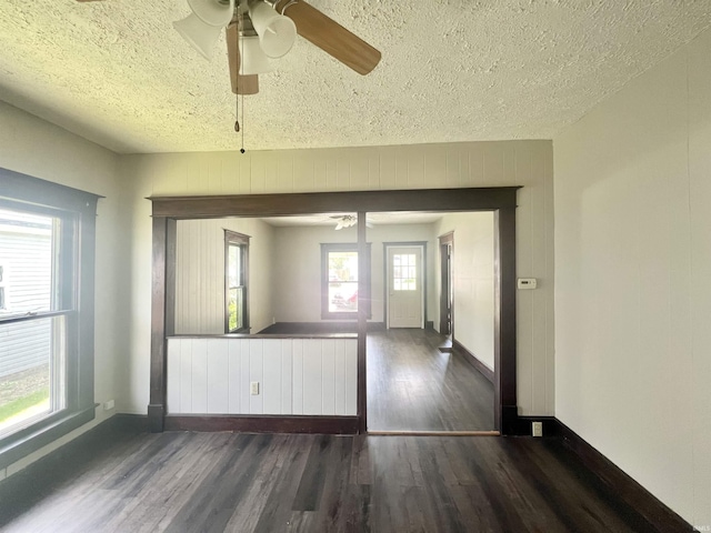 empty room featuring ceiling fan, a textured ceiling, wood finished floors, and baseboards