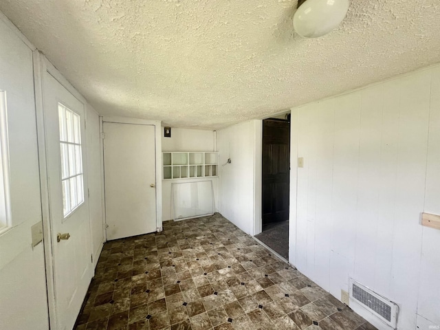 unfurnished room with a textured ceiling
