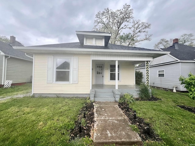 bungalow-style home with covered porch and a front yard