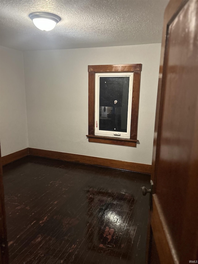 2931 Alexander St, Fort Wayne, IN 46806 - empty room with dark wood finished floors, baseboards, and a textured ceiling