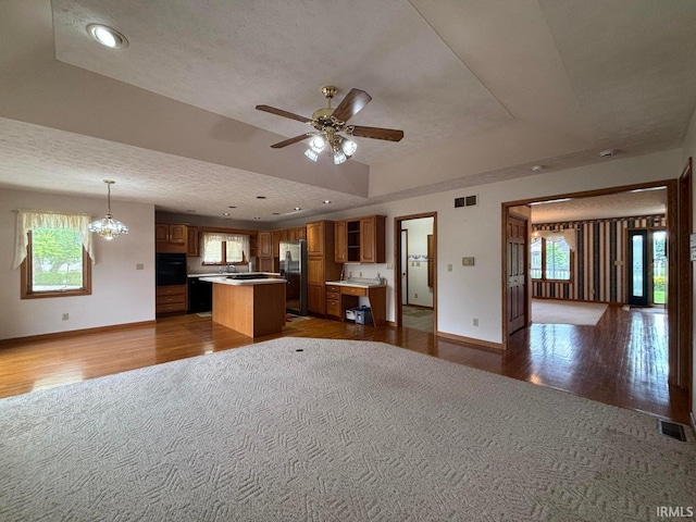 kitchen with wood finished floors, a kitchen island, oven, baseboards, and recessed lighting