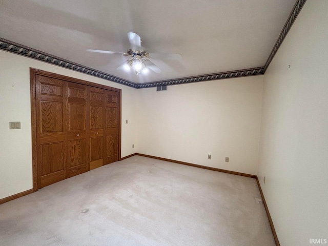unfurnished bedroom featuring light carpet, baseboards, and a closet