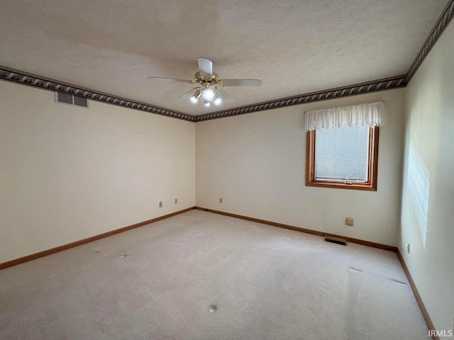 unfurnished room featuring a ceiling fan, light colored carpet, baseboards, and a textured ceiling