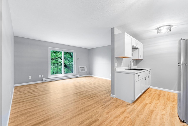 2937 Westbrook Dr Unit A-314, Fort Wayne, IN 46805 - kitchen featuring a baseboard heating unit, a sink, light wood-style floors, light countertops, and white cabinets