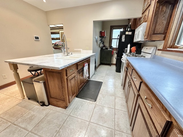 1655 Hinton Dr, Fort Wayne, IN 46808 - kitchen with a sink, white appliances, light countertops, a kitchen bar, and baseboards