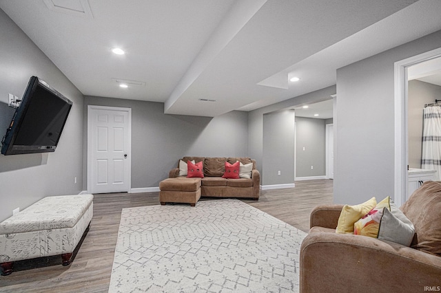 living room featuring wood finished floors, baseboards, and recessed lighting