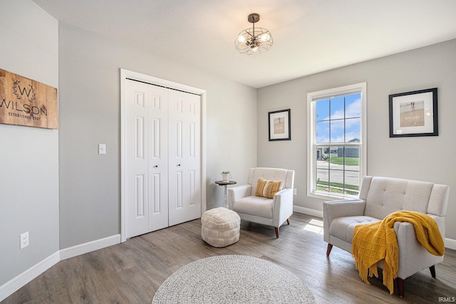 sitting room featuring wood finished floors, baseboards, and a chandelier