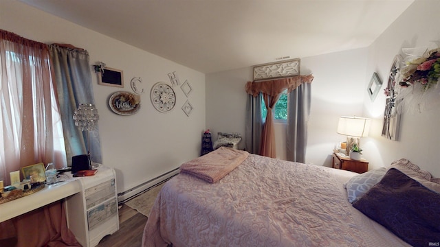 bedroom with baseboard heating and wood finished floors