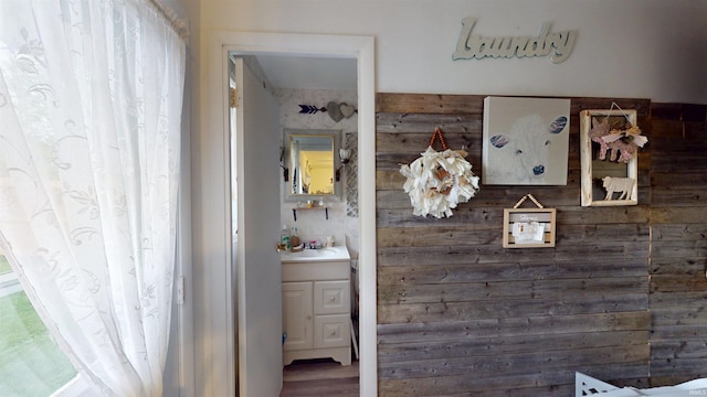 hall featuring a sink and wood finished floors