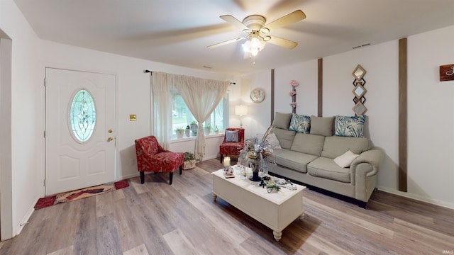 living room with light wood-style flooring, ceiling fan, and baseboards