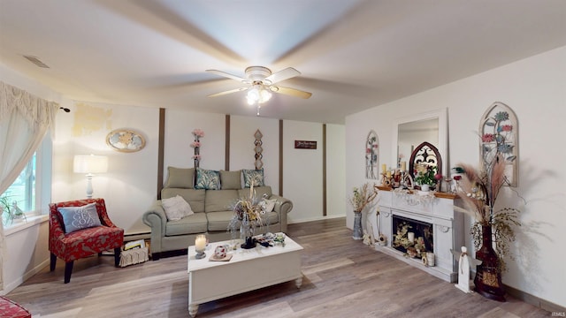 living area featuring a ceiling fan, light wood-style floors, and baseboard heating