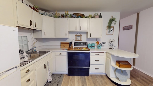 kitchen featuring freestanding refrigerator, electric range oven, open shelves, a peninsula, and a sink