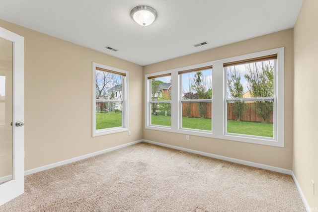 carpeted empty room featuring baseboards