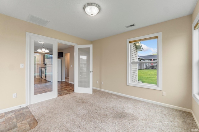 carpeted empty room with baseboards and french doors
