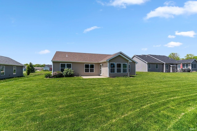 back of house featuring a patio area and a lawn