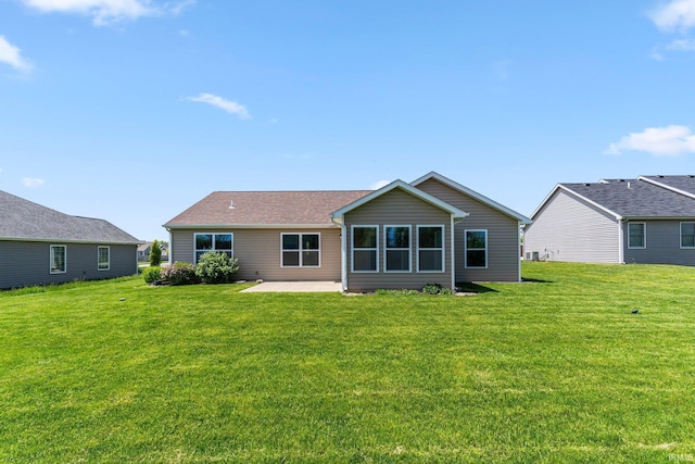back of house with a patio area and a lawn