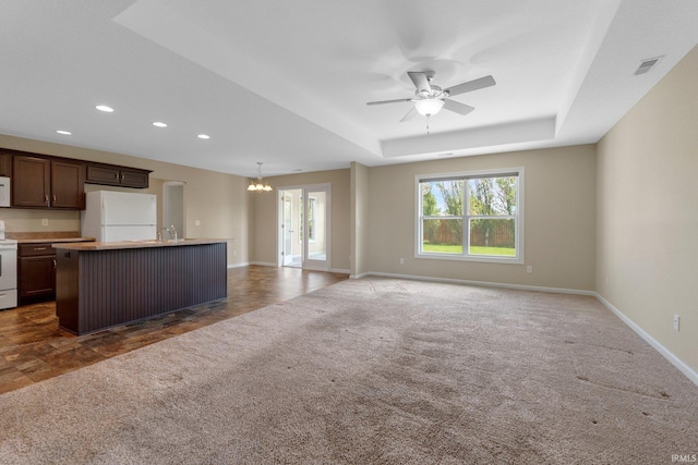 kitchen with white appliances, open floor plan, a chandelier, recessed lighting, and an island with sink