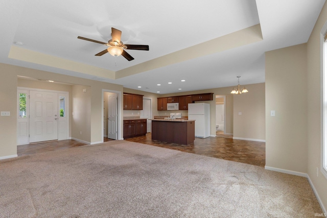 unfurnished living room with carpet flooring, a chandelier, baseboards, and recessed lighting