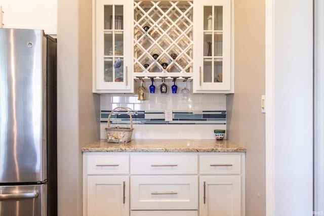 indoor dry bar with freestanding refrigerator and backsplash