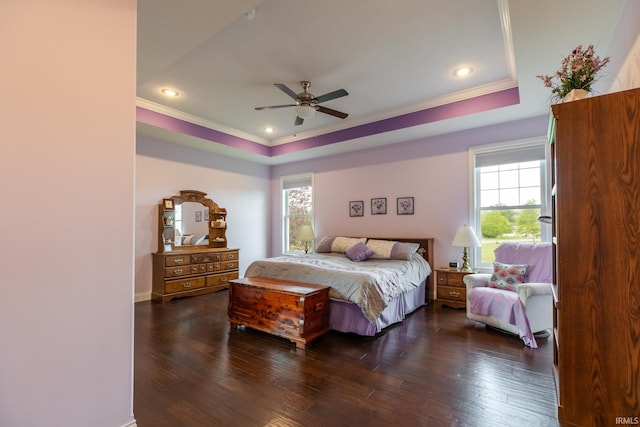 bedroom with a raised ceiling, crown molding, multiple windows, dark wood-style flooring, and recessed lighting