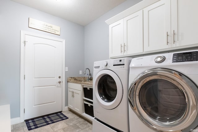 washroom with washing machine and clothes dryer, cabinet space, and baseboards