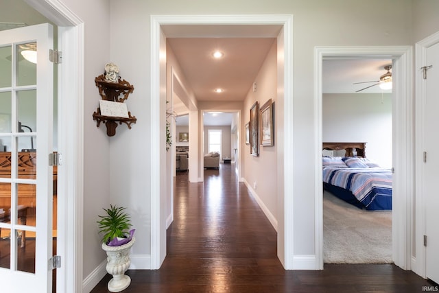 hallway featuring dark wood-style flooring, baseboards, and recessed lighting