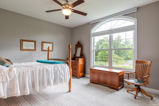bedroom with light colored carpet, baseboards, and a ceiling fan