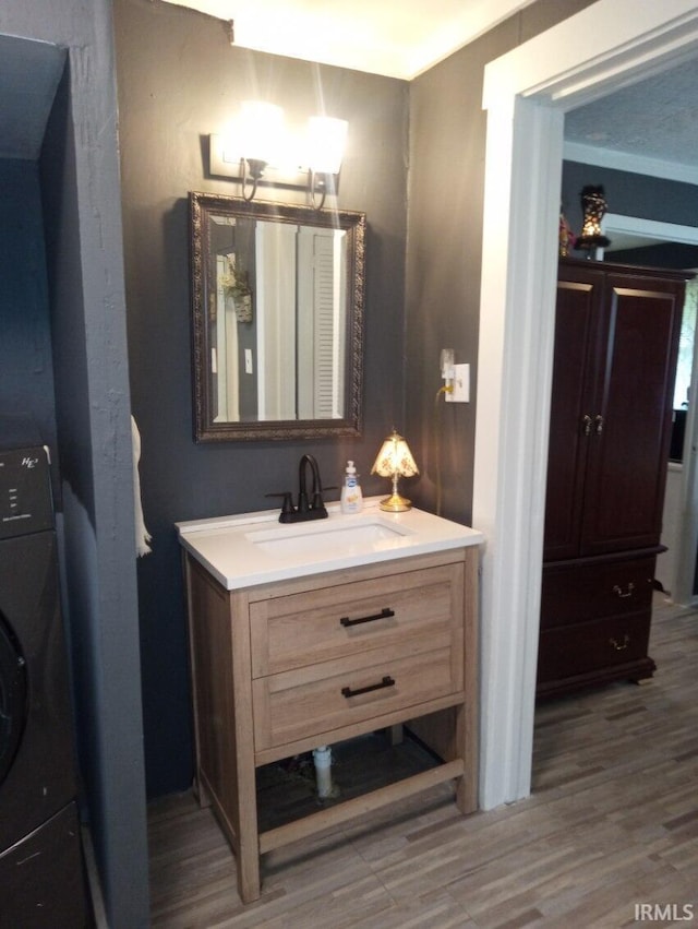 bathroom with washer / clothes dryer, wood finished floors, and vanity