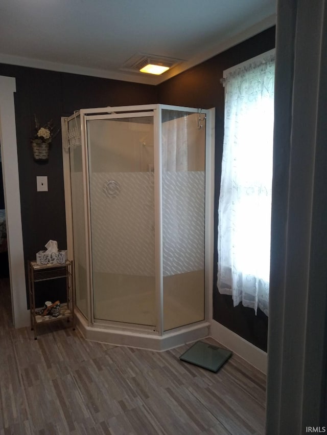 full bathroom featuring wood finished floors and a stall shower