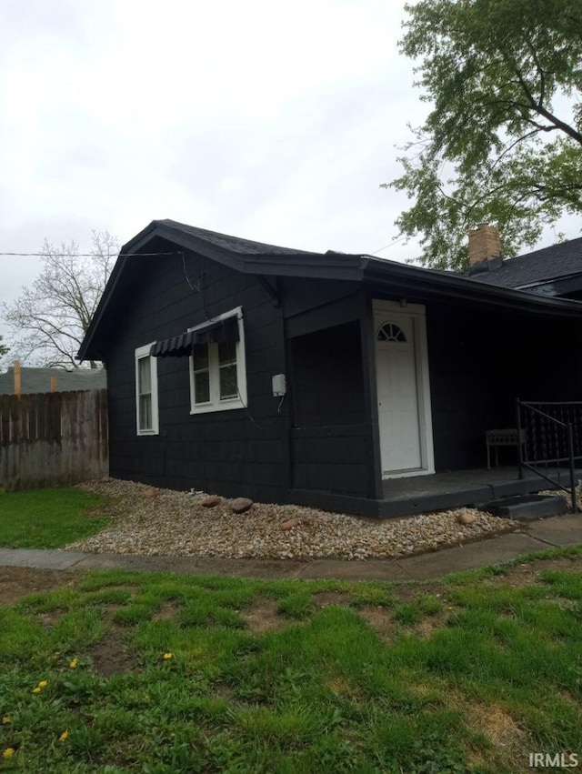 view of home's exterior featuring fence and a chimney