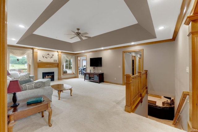 2102 Hunters Ct, Auburn, IN 46706 - carpeted living room with a tray ceiling, a ceiling fan, a glass covered fireplace, baseboards, and recessed lighting