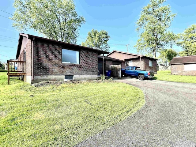 ranch-style house featuring brick siding, driveway, and a front lawn