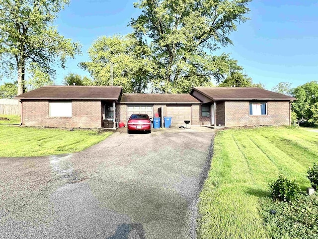 ranch-style house with an attached garage, asphalt driveway, brick siding, and a front yard