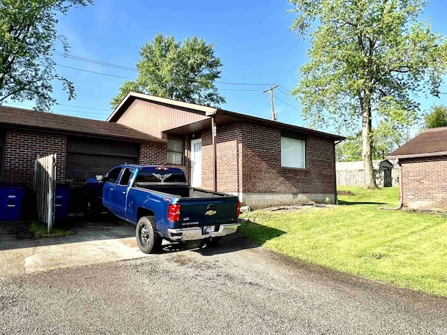 view of front of house with a garage, brick siding, a front yard, and asphalt driveway