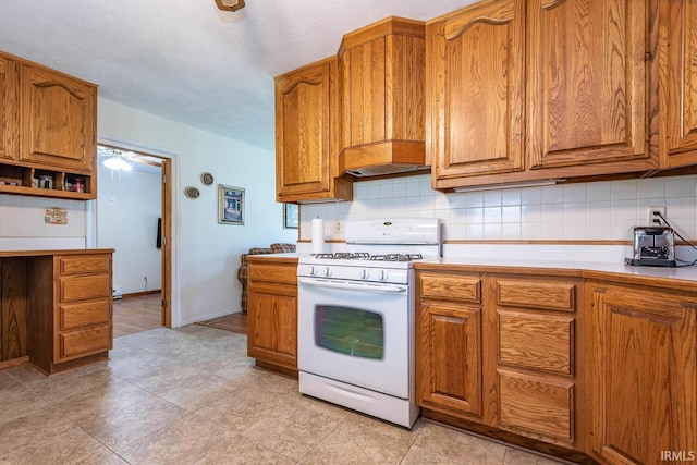 3721 W Maybury Mall, Bloomington, IN 47403 - kitchen featuring white range with gas stovetop, decorative backsplash, brown cabinetry, light countertops, and light tile patterned floors