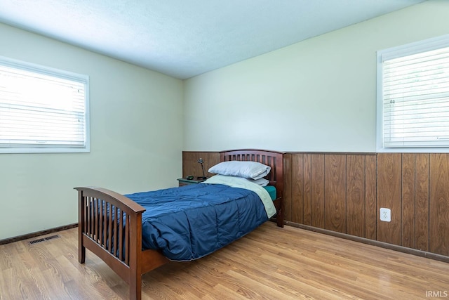 3721 W Maybury Mall, Bloomington, IN 47403 - bedroom featuring wood finished floors, multiple windows, a wainscoted wall, and wood walls