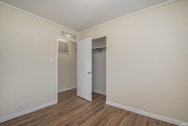 unfurnished bedroom with wood finished floors, baseboards, a closet, and ornamental molding