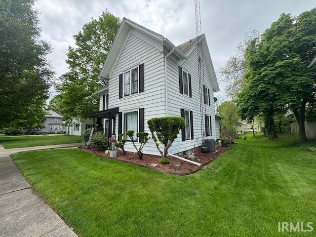 view of property exterior with a yard and central AC